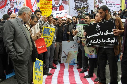 IRAN, Tehran: Protesters step on a flag of the US as hundreds of people march in front of the former US embassy in Tehran, during the '13 Aban' (4th of November in english), on November 4, 2015, to commemorate the anniversary of the 1979 US embassy taking.