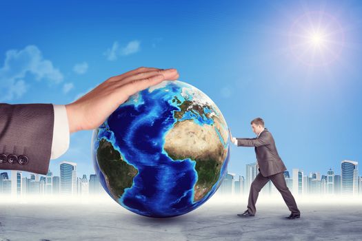 Businessman pushing Earth on abstract background. Elements of this image furnished by NASA