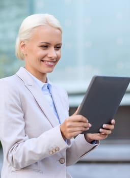 business, education, technology and people concept - smiling businesswoman working with tablet pc computer on city street