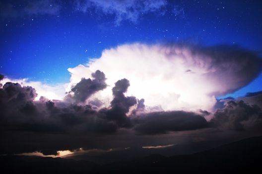 Carpathian Mountains. Mount Pop Ivan. Thunderhead and the starry sky above the ridge Montenegrin