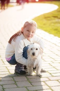 Little girl with her puppy dog in the park