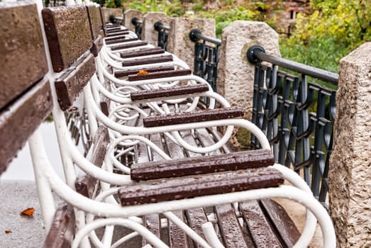 Bench with raindrops in the autumn park