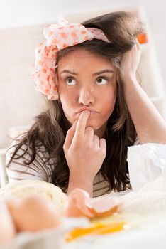 Young woman thinking and making dough