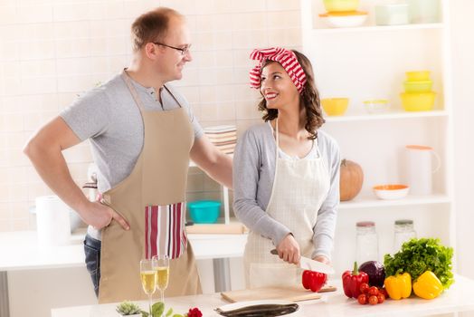 Happy couple preparing food in the kitchen.