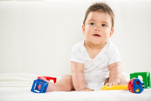 Cute baby boy sitting at home with toys