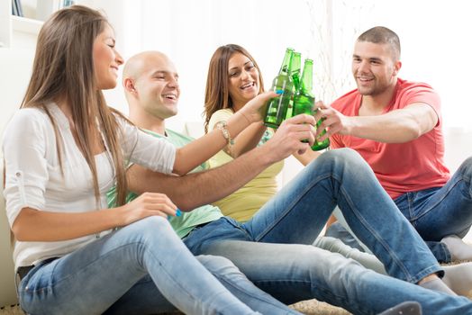 Friends enjoying with beer and cheers together at home party.