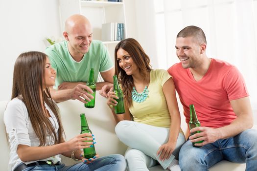 Four friends enjoying with beer together at the home party.