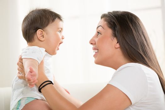 Mother and baby sitting and playing at home