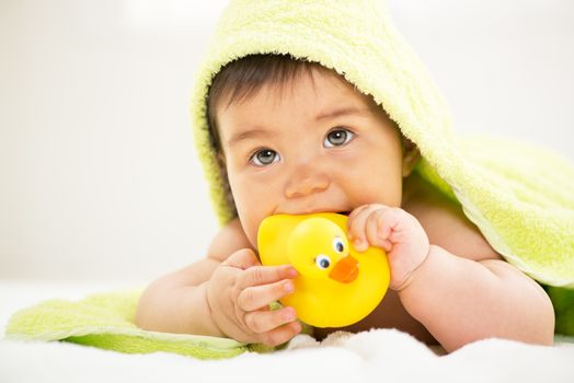 Cute baby boy lying under a towel