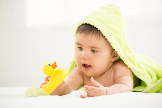 Cute baby boy lying under a towel