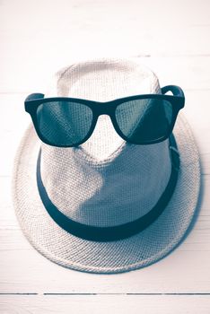 hat and sunglasses on white table vintage style