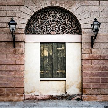 Facade of an ancient Italian villa with artistic iron grill handmade.