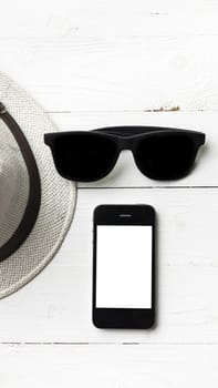 hat sunglasses and smart phone on white table