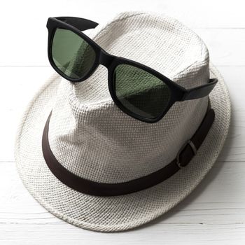 hat and sunglasses on white table