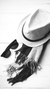 hat and blue with sunglasses scarf on white table black and white color