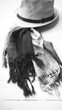 hat and blue scarf on white table black and white color