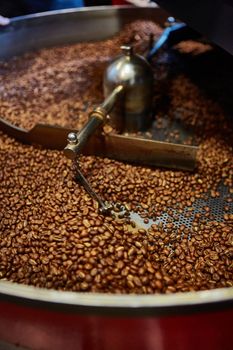 Freshly roasted coffee beans in a coffee roaster. Shallow dof