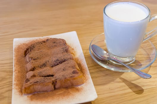 Hot milk and bread on table.