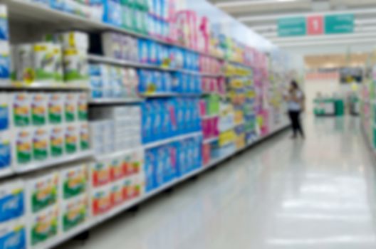 blurred image of supermarket people shopping - product shelf