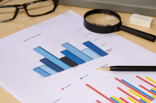 Financial graphs analysis and pen.