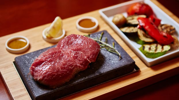 meat grilled on a stone with vegetables on the plate