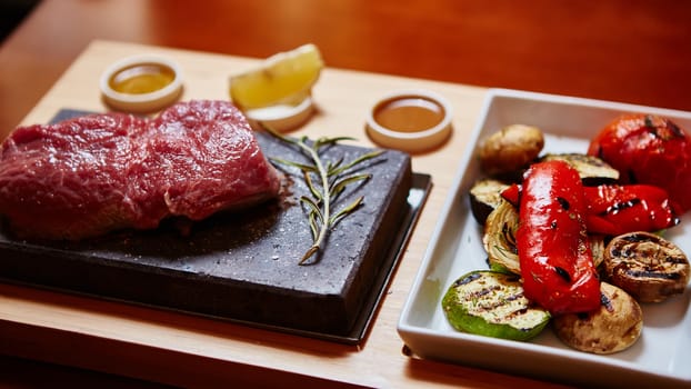 meat grilled on a stone with vegetables on the plate