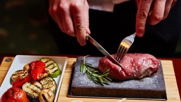 meat grilled on a stone with vegetables on the plate
