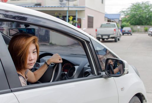 Female driver looking very happy driving a car