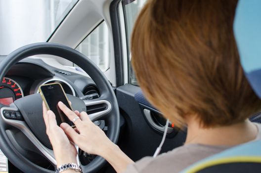 Woman hand using smartphone on driving car