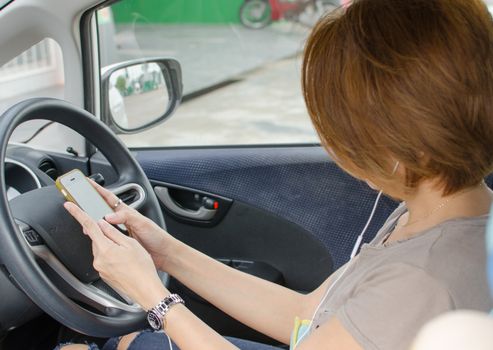 Woman hand using smartphone on driving car