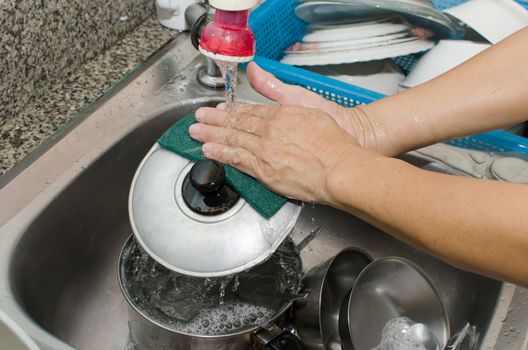 Washing kitchen ware on the sink