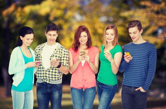 education and modern technology concept - smiling students with smartphones