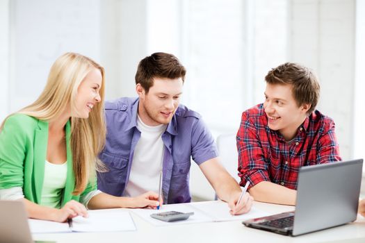 education concept - smiling students chatting in lecture at school