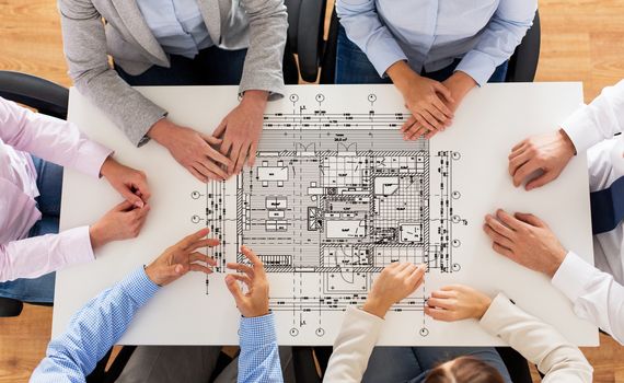 business, people, architecture and team work concept - close up of architects team hands and blueprint on office table