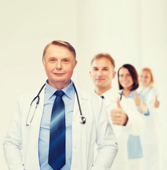 healthcare and medicine concept - smiling standing doctor or professor with stethoscope