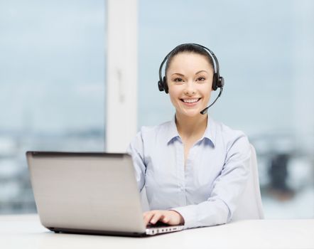 business, communication and call center concept - friendly female helpline operator with headphones and laptop computer