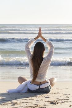woman doing yoga on the beach