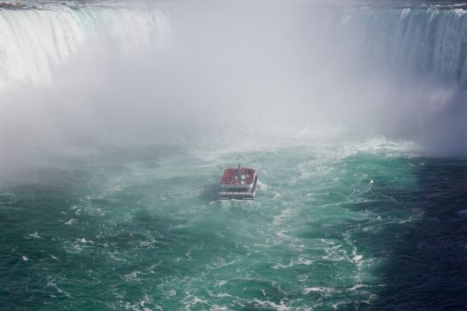 Beautiful photo with the lonely ship in the mist of the Niagara falls