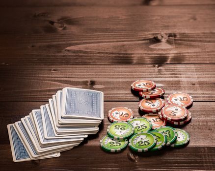 old vintage cards and a gambling chip on a wood table.