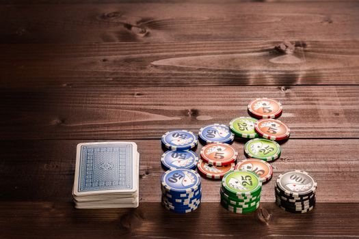 old vintage cards and a gambling chip on a wood table.