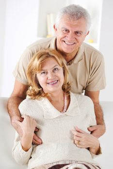 Hugging Senior couple in living room.