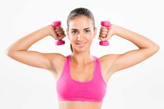 Portrait of a young beautiful woman exercising with dumbbells.