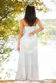 Young beautiful woman in white dress relaxing in the nature.