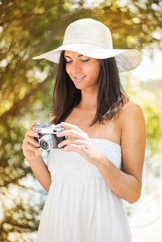 Young beautiful woman in the nature with retro photo camera.