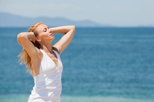 Young Beautiful Woman Relaxing on the beach and reaching for the great sun.