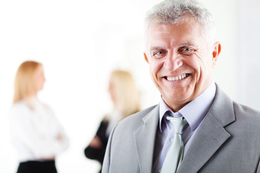 Happy senior businessman in the office. Looking at camera. Selective Focus.