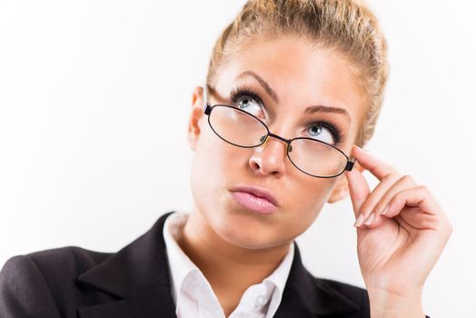 Portrait of attractive businesswoman with glasses. She is thinking and looking up.