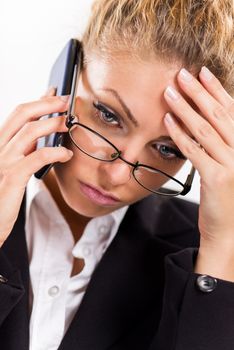 Portrait of attractive businesswoman with glasses using a mobile phone. She is thinking.