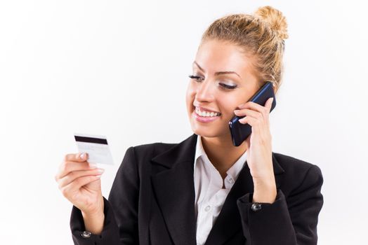 Businesswoman telephoning and holding a credit card.