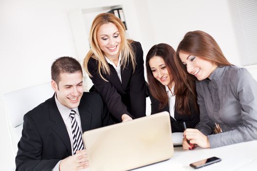 Happy Business woman showing her colleagues project at laptop in the office.